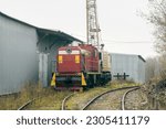 Repair service train with railroad crane, shunting locomotive, wrecking train in railway depot. Industrial railroad equipment