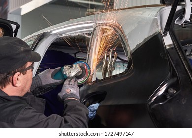 Repair service worker fix damaged car. Working with angle grinder to fix metal body. - Powered by Shutterstock