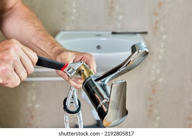 Repair work in bathroom, plumber installing new tap in home water supply system.