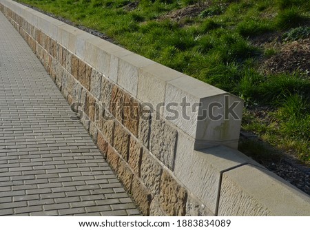repaired renovated sandstone walls near the cemetery. stairs and railings of the wall made of new stone which weatheres quickly but is beautiful and beige from large easily workable blocks.  sloping