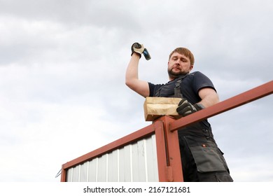 Repairer Pounding Fence Post With Hammer In Summer