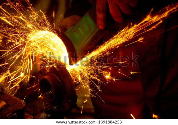 repairing auto in car workshop - repairer cut
metal on car by angle grinder with
sparks