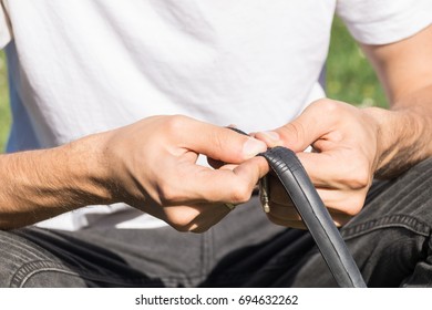 Repairing Bicycle Tube Outdoors During Trip. Close Up Image Of Person Using Repair Patch Kit To Fix Inner Tube Damage Of Bicycle Wheel On The Road