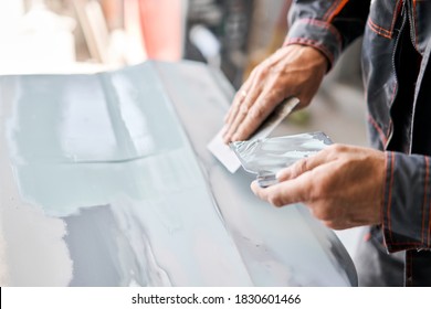 Repairing car body, Application putty close up. The mechanic repair the car. Work after the accident by working sanding primer before painting. - Powered by Shutterstock