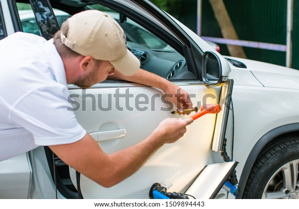 Repairing car dent after the accident by paintless\
dent repair