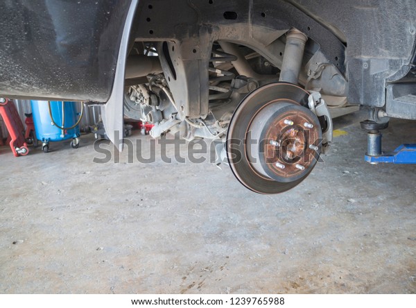 Repairing the car disk\
brakes in the garage.