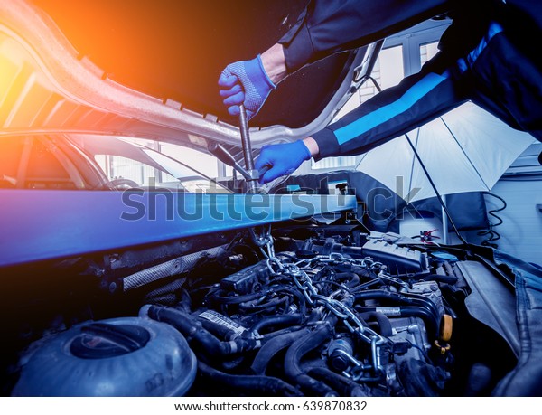 Repairing engine at service station. Car\
repair. Background
