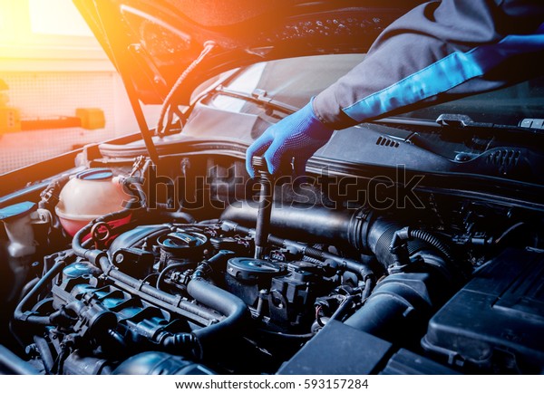 Repairing engine at service station.\
Engine compression measurement. Car repair.\
Background
