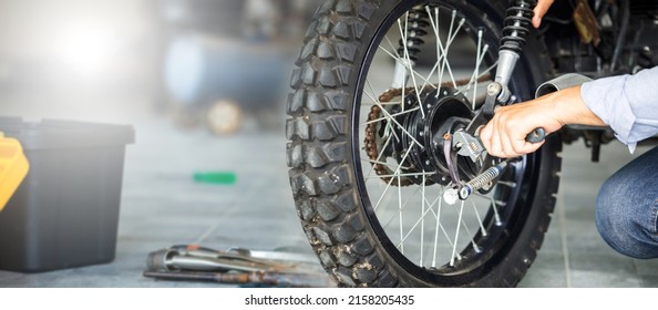 Conceptos de reparación y mantenimiento, Motocicleta de reparación de hombres en taller de reparación, Motocicleta de fijación mecánica en taller garaje con fondo borroso