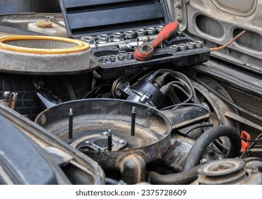 repairing an old car engine with a carburetor