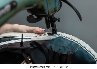 Repairing sneakers. Man repairing a sneaker by using a sewing machine. handcraft workshop concept. - Powered by Shutterstock