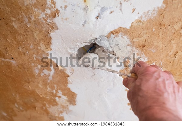 Repairing the wall - Man putting spackle on a hole\
in the wall