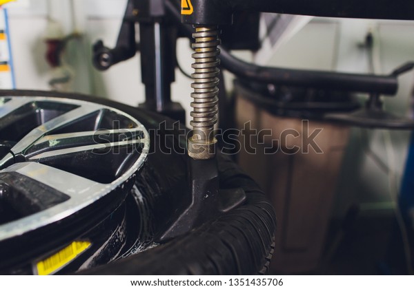 repairman balances the wheel
and installs the tubeless tire of the car on the balancer in the
workshop.