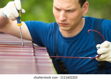 Repairman In Blue Suit Cleans And Strengthens The Roof Surface, Close-up