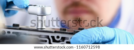 Repairman car-care center on repair of automatic transmissions holds in hand horn key carries out disassembling assemblage hydroblock detail carries diagnostics makes an estimation of working capacity