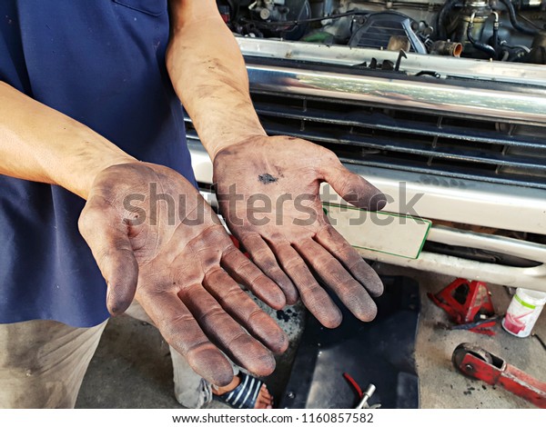 The repairman of\
cars wipes hands from oil