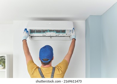 Repairman cleaning and fixing indoors AC unit. - Shutterstock ID 2169611473