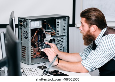 Repairman Disassembling Computer Unit For Repair. Bearded Man Taking Electronic Component Out Of CPU. Renovation, Fix, Construction Concept