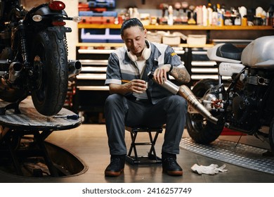 Repairman drinking coffee in his garage after finishing work on big project - Powered by Shutterstock