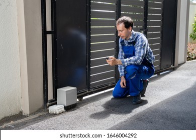Repairman Fixing Broken Automatic Door In Building