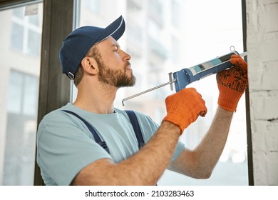 Repairman Fixing Window With Silicone Adhesive Gun