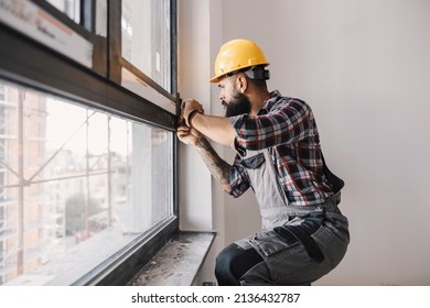 A repairman fixing windows in new apartment. - Shutterstock ID 2136432787