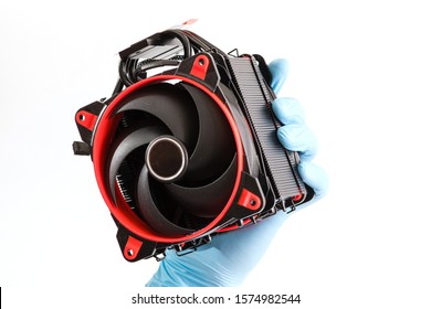 Repairman hand in blue runnber glove hold computer spare part with cpu, red fan and wires at white isolated background