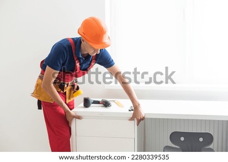 repairman installs furniture in the children's room