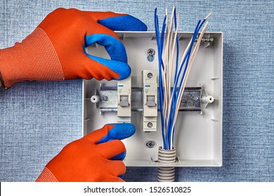 The Repairman Installs A New Electrical Panel With Automatic Fuses For The Household Electric Network. Installation Of The Switchboard In The Home Electricity System, Install The Fuse Box.