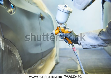 repairman painter in chamber painting automobile car bonnet