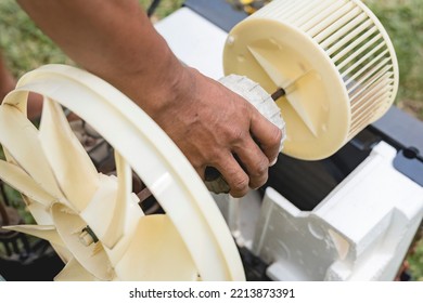 A Repairman Removes The Motor, Blower And Condenser Fan From A Window Type AC. Air Conditioner Repair.