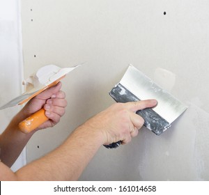repairman works with plasterboard, plastering dry-stone wall, home improvement