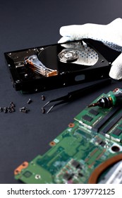 Repairs broken computer hard disk drive by engineer. Disassembled hard drive disk from the computer. HDD troubleshooting.