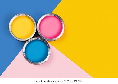 Repare concept. Tricolor blue, yellow, pink background with three colors paint cans. Flat lay, top view, copy space.