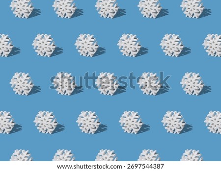 A repeat pattern of a snowflake ornament on a light blue background.