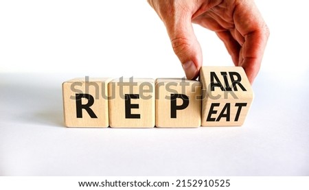 Repeat and repair symbol. Businessman turns a wooden cube and changes the word repeat to repair. Beautiful white table, white background, copy space. Business, repeat and repair concept.