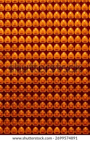 Repeated religious objects in a temple, gold and orange, symbolizing luck, fortune, and abundance, including lanterns and figures, with decorative patterns throughout.