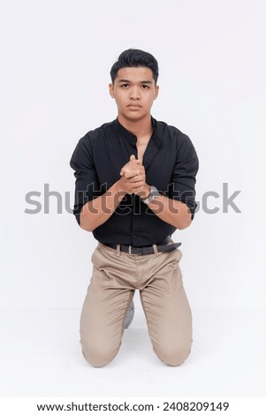 A repentful man kneeling down, asking for a second chance. Asking forgiveness for his shortcomings. Studio shot isolated on a white background.