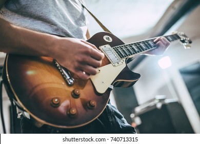 Повторение рок-музыки группы. Обрезанное изображение электрического гитариста. Репетиционная база