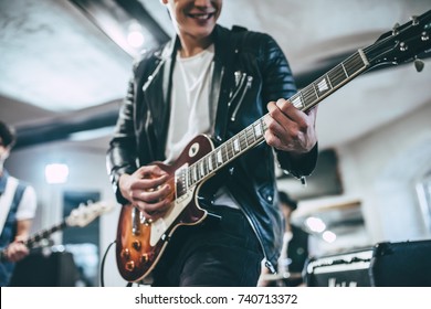 Repetition of rock music band. Cropped image of electric guitar player and drummer behind the drum set. Rehearsal base - Shutterstock ID 740713372