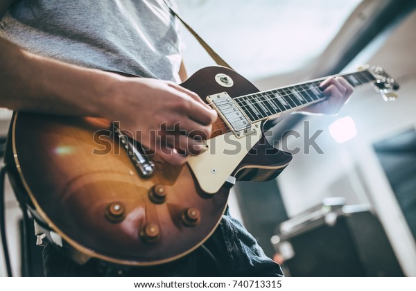 Repetition of rock music band. Cropped\
image of electric guitar player. Rehearsal\
base