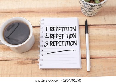 Repetition, text words typography written on book against wooden background, life and business motivational inspirational concept