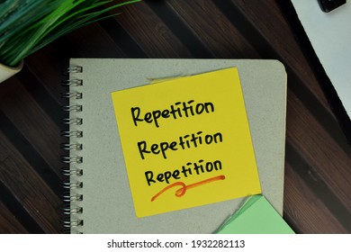 Repetition, Repetition, Repetition write on sticky notes isolated on Wooden Table. Selective focus on Repetition text