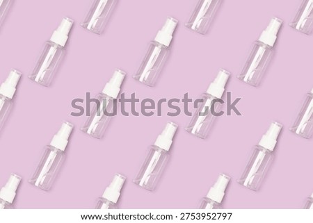 Repetitive pattern made of empty transparent spray bottle on a purple background.