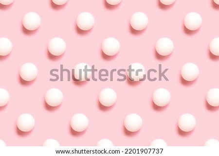 Repetitive pattern made white ping pong ball on a pink background. Creative layout.