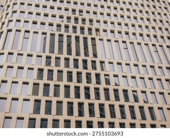 Repetitive Pattern Of Tall Skyscraper Windows Reflecting Sky and the nearby building.