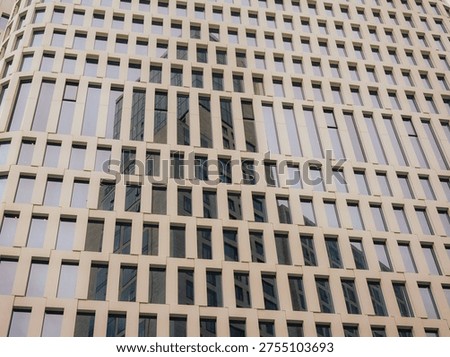 Repetitive Pattern Of Tall Skyscraper Windows Reflecting Sky and the nearby building.