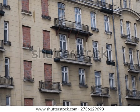 Repetitive pattern of windows and wrought iron balconies on a city building