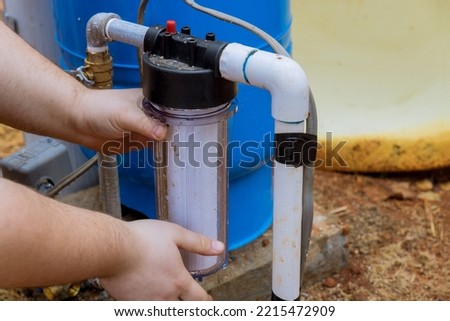 Replace replaceable filters for cleaning water near home by professional workers performing maintenance work replacing replaceable filters in outside parts of house