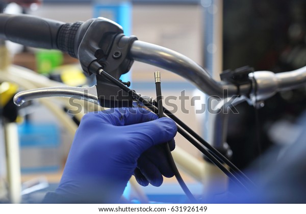 
Replacement of brake
cable in bicycle brakes. The mechanic in the bike service repairs
and adjusts the
brakes.
